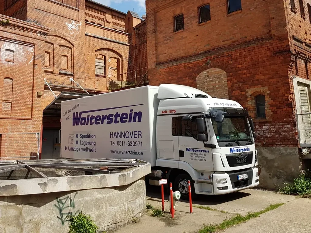 Walterstein Lkw bei einem Transport vor einem historischen Backsteingebäude